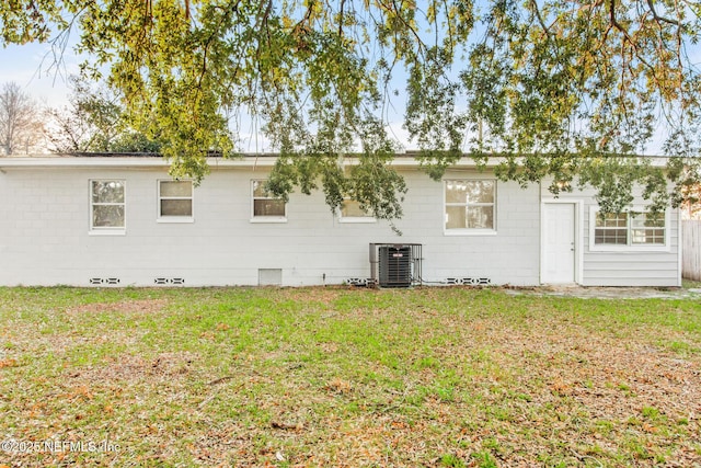 back of property featuring central AC unit and a yard