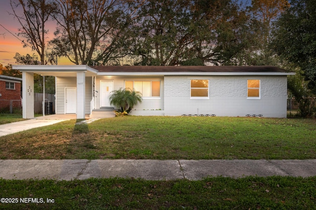 single story home featuring a lawn and a carport