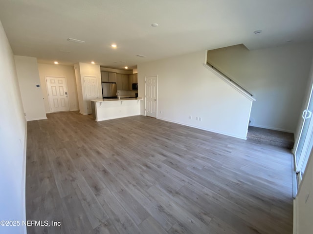 unfurnished living room featuring light hardwood / wood-style flooring and sink