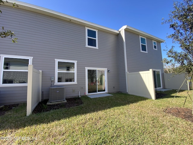 rear view of property with a lawn and central AC