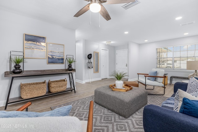 living area featuring baseboards, wood finished floors, visible vents, and recessed lighting