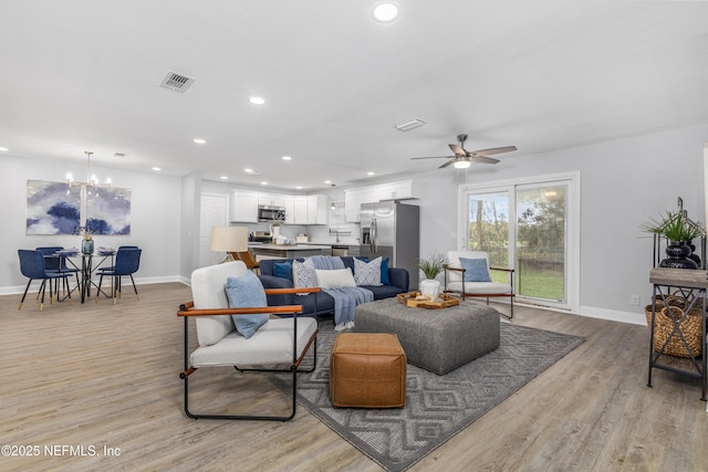 living room with recessed lighting, visible vents, light wood-style flooring, and baseboards