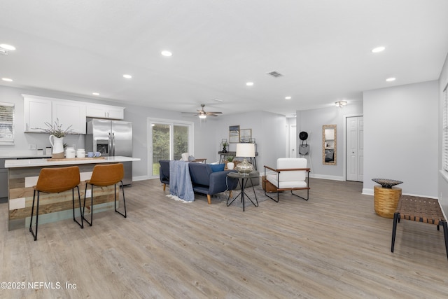 living area featuring light wood finished floors, visible vents, and recessed lighting