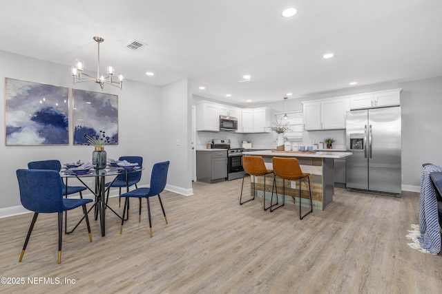 interior space featuring visible vents, light wood-style flooring, and baseboards