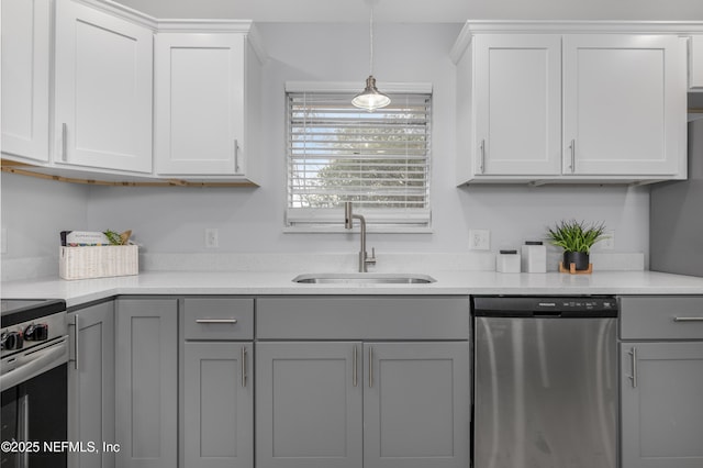 kitchen featuring stainless steel appliances, gray cabinets, light countertops, white cabinetry, and a sink