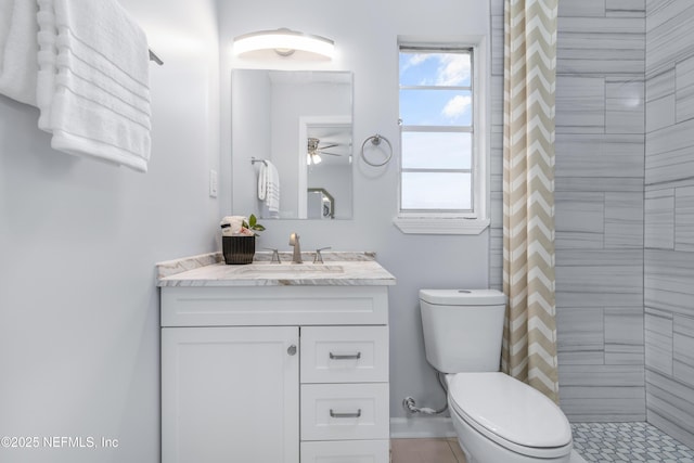 bathroom featuring toilet, a healthy amount of sunlight, a tile shower, and vanity