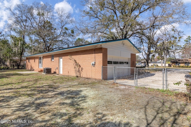 view of property exterior featuring a detached garage, a gate, fence, cooling unit, and brick siding