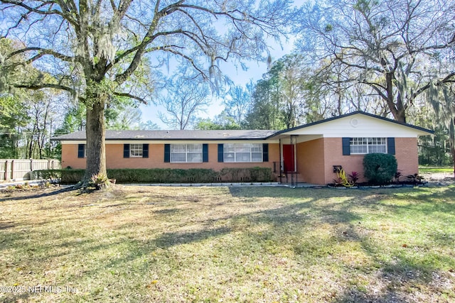 single story home featuring brick siding, a front lawn, and fence