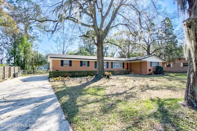 single story home featuring fence and a front lawn