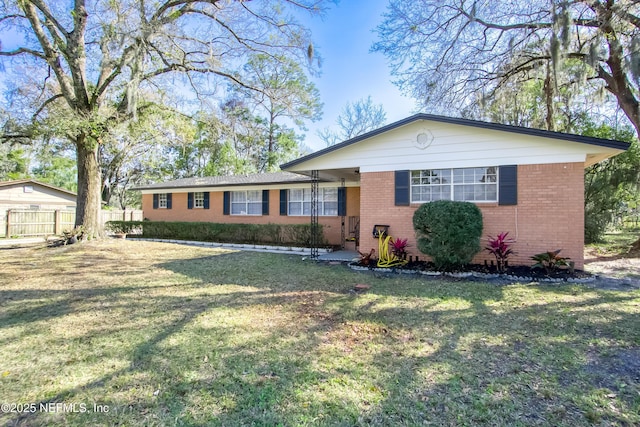 view of front of home featuring brick siding, a front yard, and fence