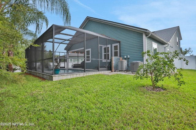 rear view of house with cooling unit, a yard, a pool, and glass enclosure