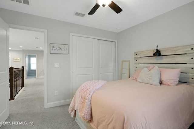 bedroom with ceiling fan, light colored carpet, and a closet