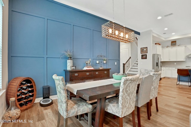 dining space featuring light hardwood / wood-style floors and a chandelier