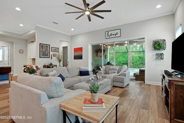 living room with light hardwood / wood-style floors, ceiling fan, a healthy amount of sunlight, and crown molding