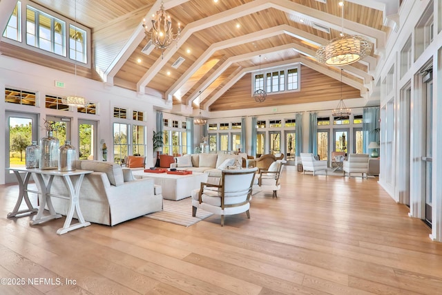 living room featuring high vaulted ceiling, a chandelier, light wood-type flooring, and french doors