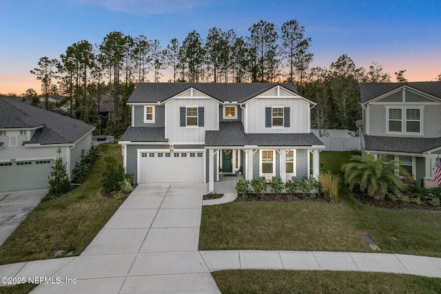 view of front of home featuring a yard, a porch, and a garage