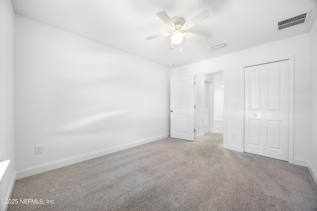 unfurnished bedroom featuring ceiling fan, a closet, and light carpet