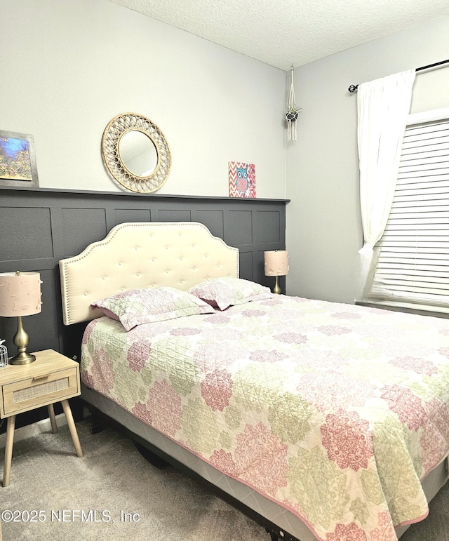 bedroom featuring a textured ceiling and carpet floors