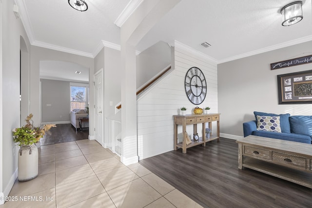 interior space featuring a textured ceiling, crown molding, and tile patterned floors