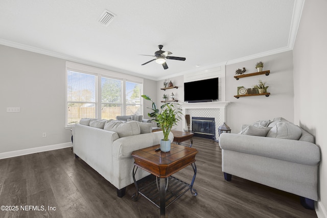 living room with ceiling fan, crown molding, a fireplace, and dark hardwood / wood-style floors