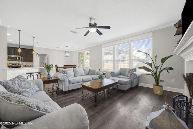 living room featuring ceiling fan, ornamental molding, and dark hardwood / wood-style flooring