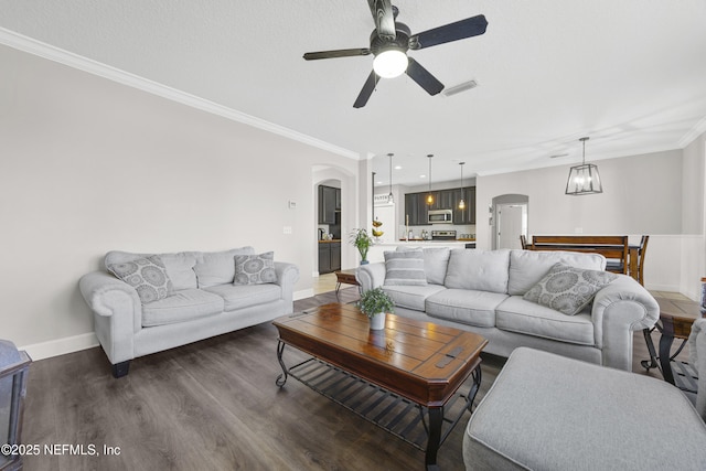 living room featuring ceiling fan, dark hardwood / wood-style floors, and ornamental molding