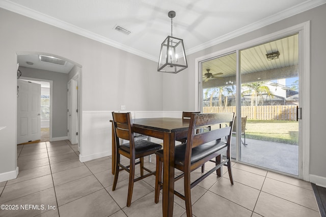 dining space with ornamental molding and light tile patterned flooring