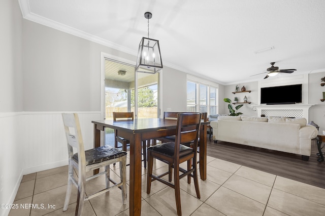 dining space featuring ceiling fan, light tile patterned floors, and ornamental molding