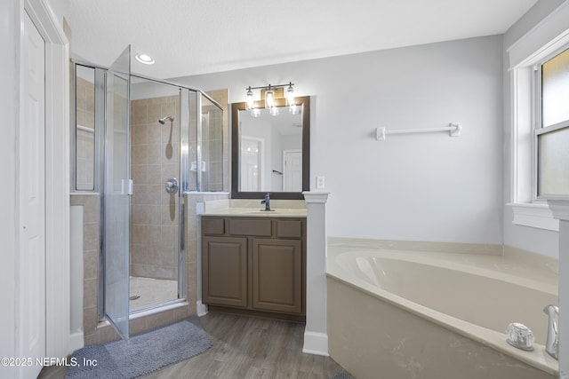 bathroom with separate shower and tub, a textured ceiling, hardwood / wood-style flooring, and vanity