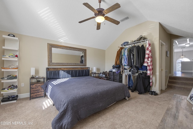 carpeted bedroom featuring vaulted ceiling, a closet, a textured ceiling, and ceiling fan