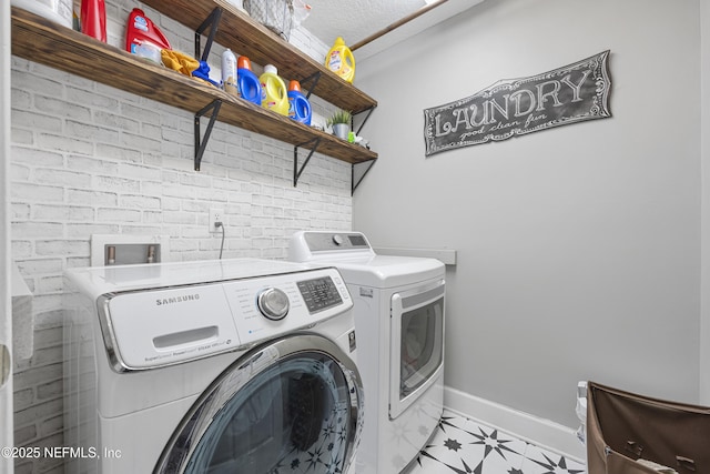 laundry room featuring separate washer and dryer and a textured ceiling