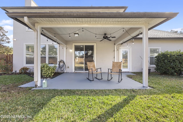 back of house featuring ceiling fan, a patio, and a yard