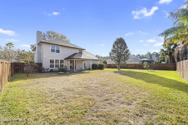 back of house with a yard and a patio