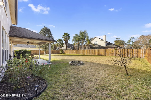 view of yard with ceiling fan, an outdoor fire pit, and a patio