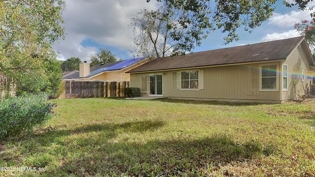 rear view of house featuring a yard