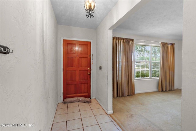 carpeted foyer entrance with a textured ceiling