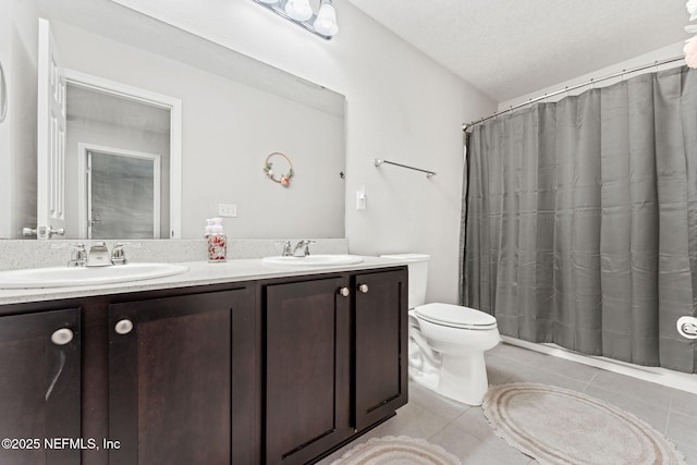 bathroom featuring tile patterned floors, vanity, toilet, and a textured ceiling