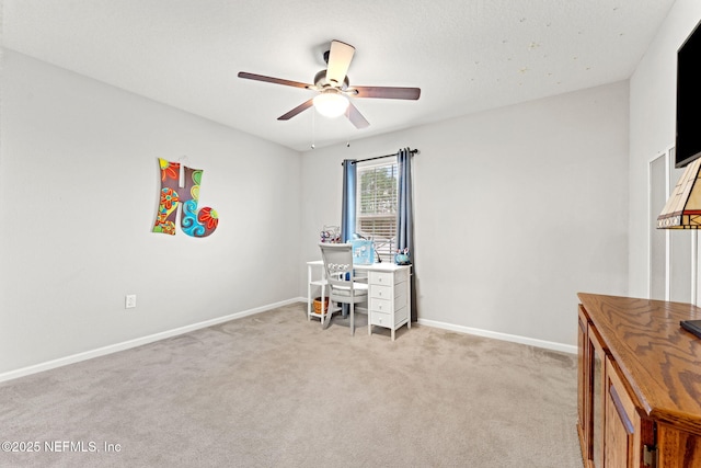 carpeted home office featuring ceiling fan