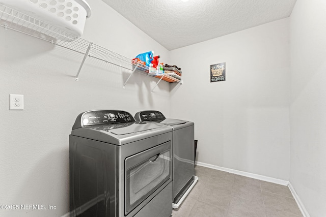 washroom with washer and clothes dryer and a textured ceiling