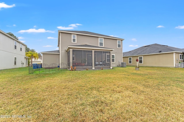 rear view of property featuring a lawn, a sunroom, and central AC unit