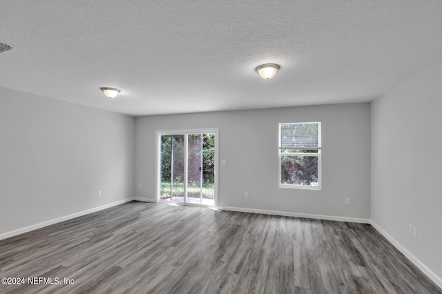 empty room featuring dark wood-type flooring and a textured ceiling