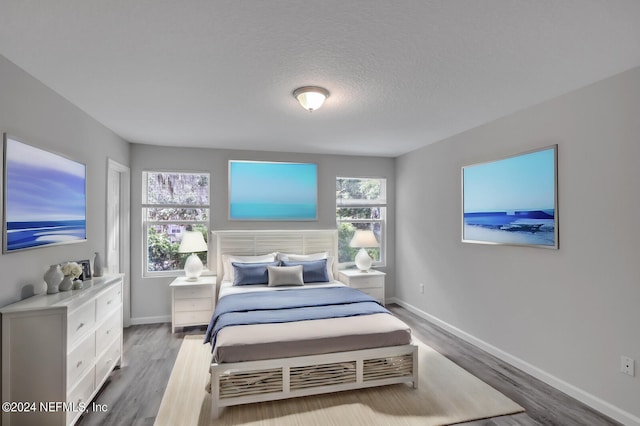 bedroom with a textured ceiling and light hardwood / wood-style flooring