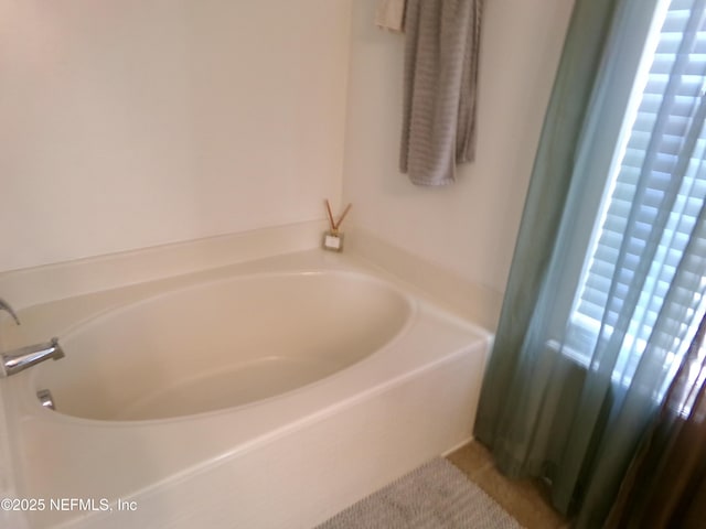 bathroom with tile patterned floors and a tub