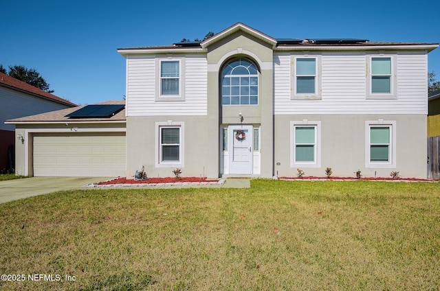 front of property with a garage, a front lawn, and solar panels