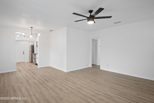 unfurnished room with ceiling fan with notable chandelier and light hardwood / wood-style floors