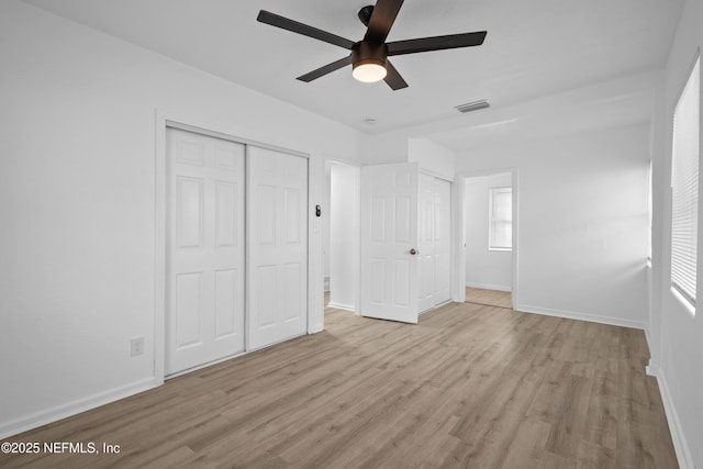 unfurnished bedroom with ceiling fan, light hardwood / wood-style floors, and a closet