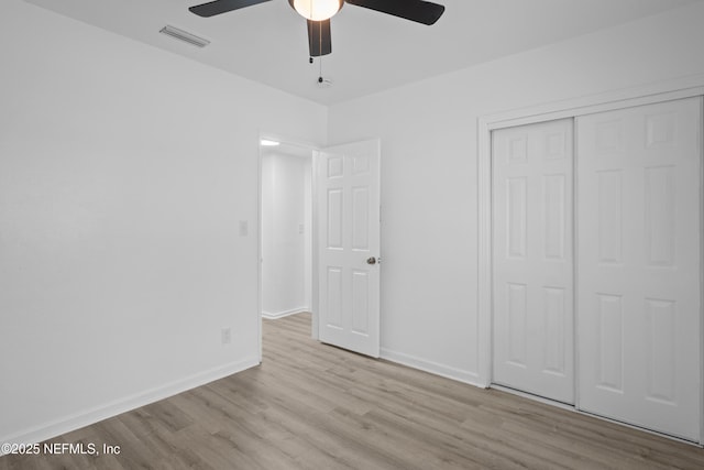 unfurnished bedroom featuring ceiling fan, a closet, and light hardwood / wood-style floors