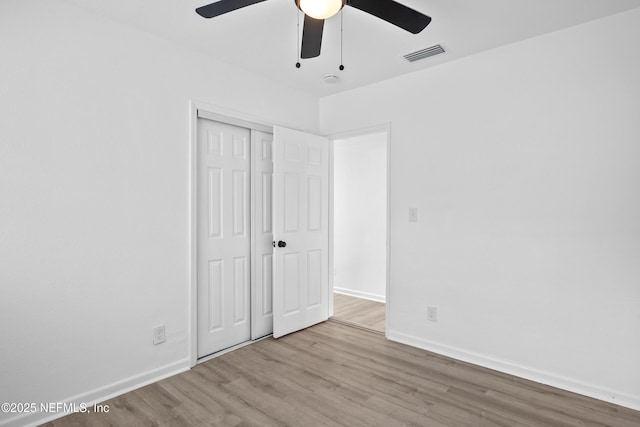 unfurnished bedroom with ceiling fan, a closet, and light hardwood / wood-style floors