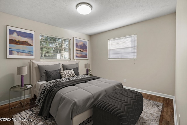 bedroom with a textured ceiling and dark hardwood / wood-style floors