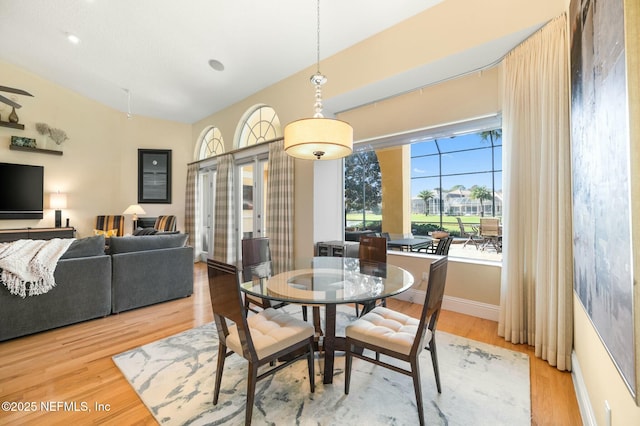 dining area featuring light hardwood / wood-style floors and vaulted ceiling